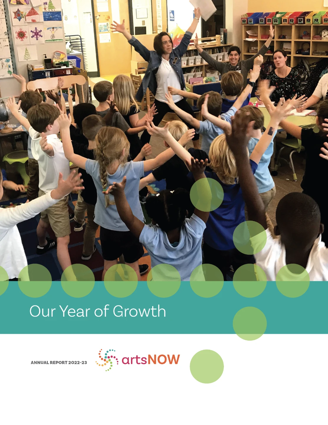 In a bustling Georgia classroom, a group of children energetically participate in an activity, eagerly raising their hands. An adult stands at the front, leading the session. This vibrant scene graces the landing page of the "artsNOW" annual report titled "Our Year of Growth.